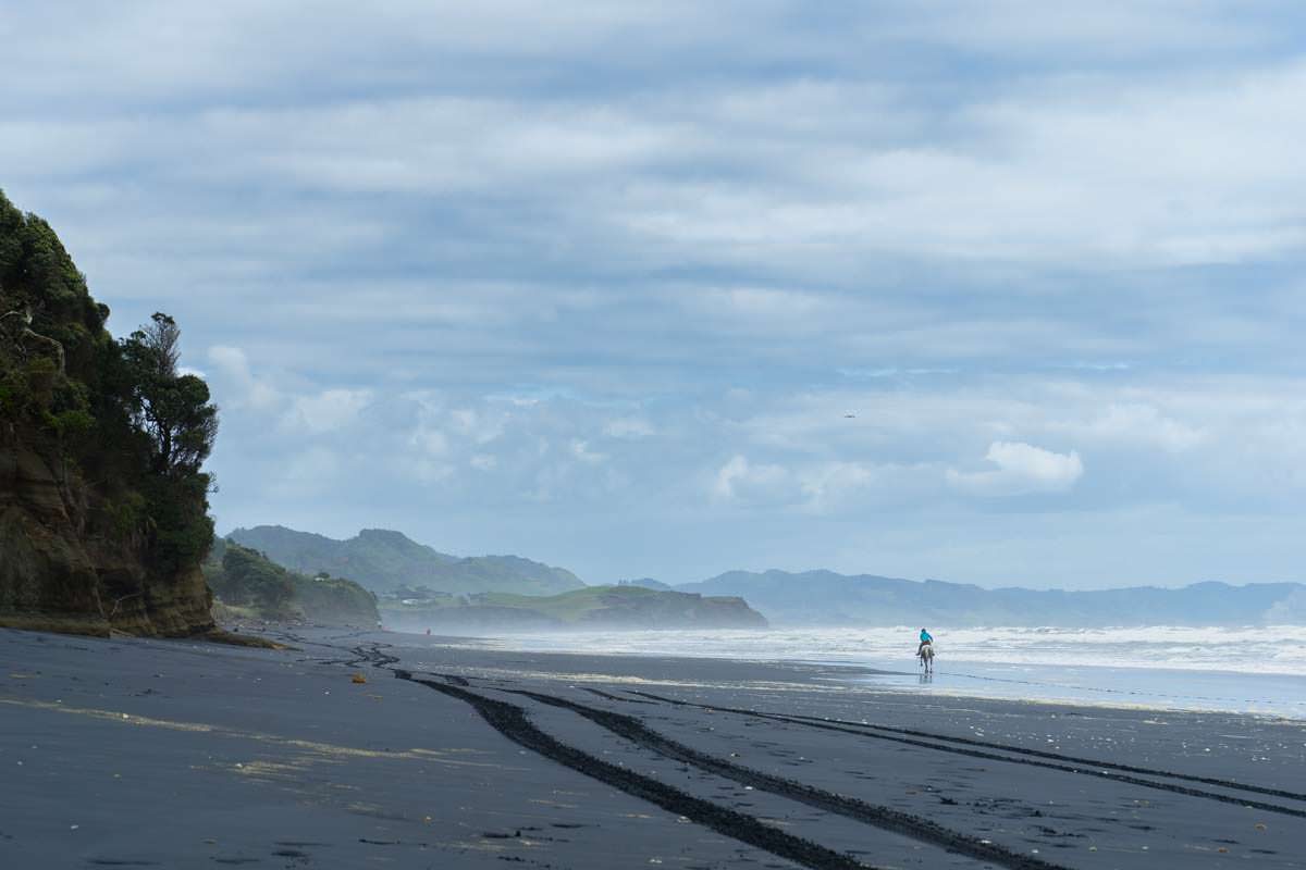 Reiterin am Awakino Beach in Neuseeland