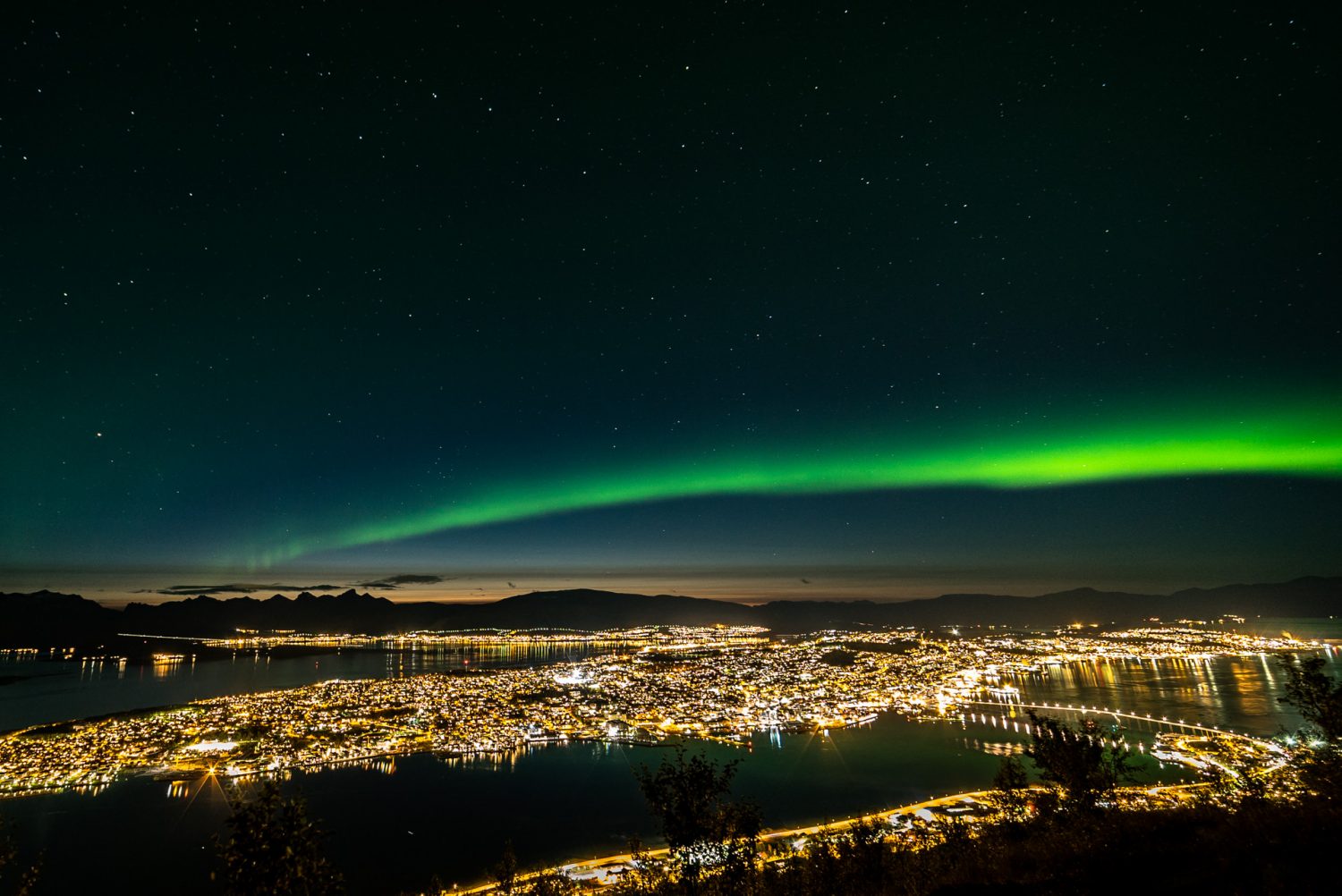 Blick vom Storsteinen über Tromsø mit Nordlichtern