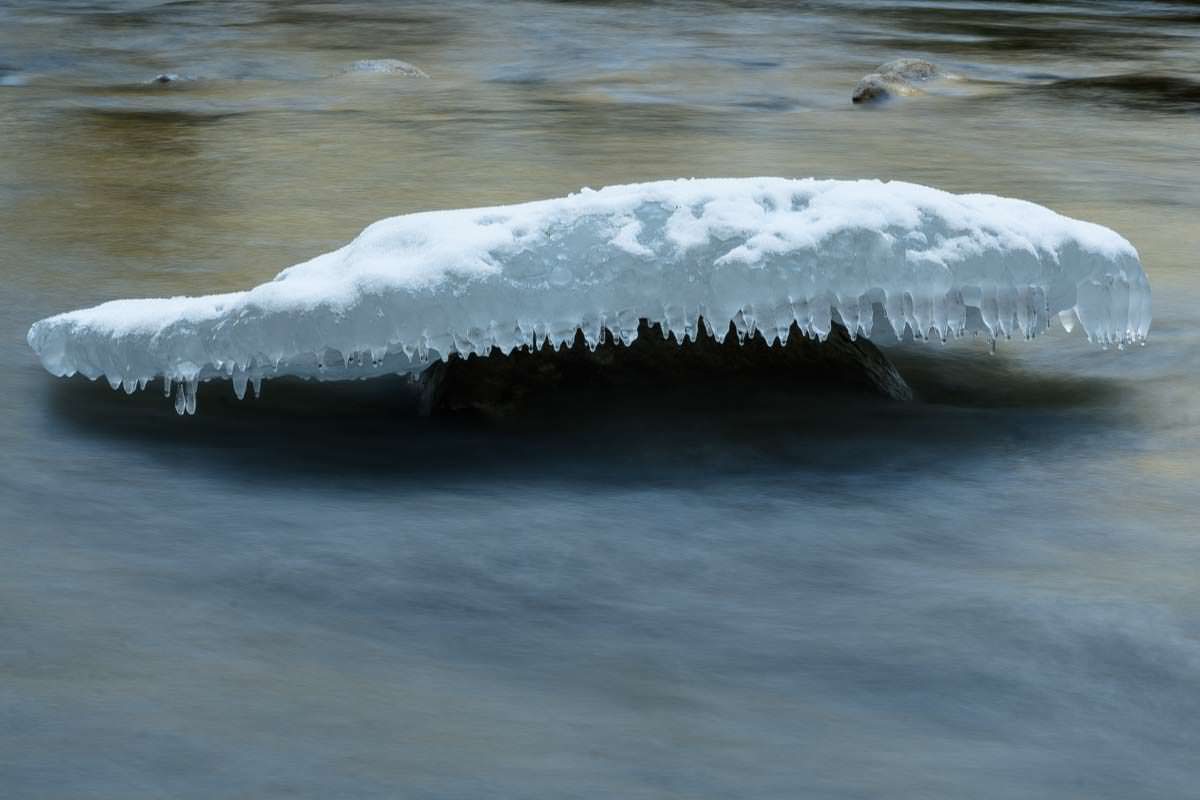 Bizarre Eisformationen bilden sich an kleinen Felsbrocken. Eisformation im Eistobel im Winter