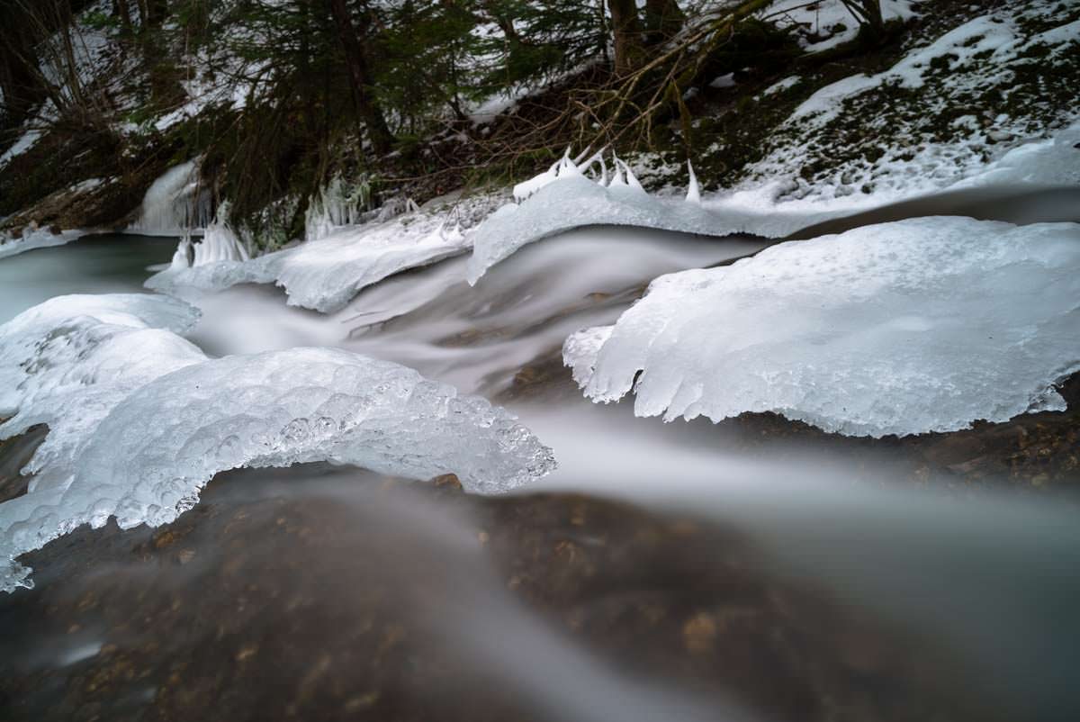 Der untere Teil vom Wasserfall am Eissteg ist teilweise eingefroren. Gefrorener Wasserfall am Eissteg (Winter im Eistobel)