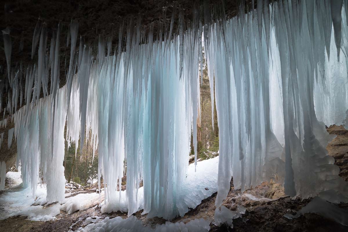 Die Eiszapfen leuchten in unterschiedlichen Farben. Eisgrotte im Eistobel (Allgäu)