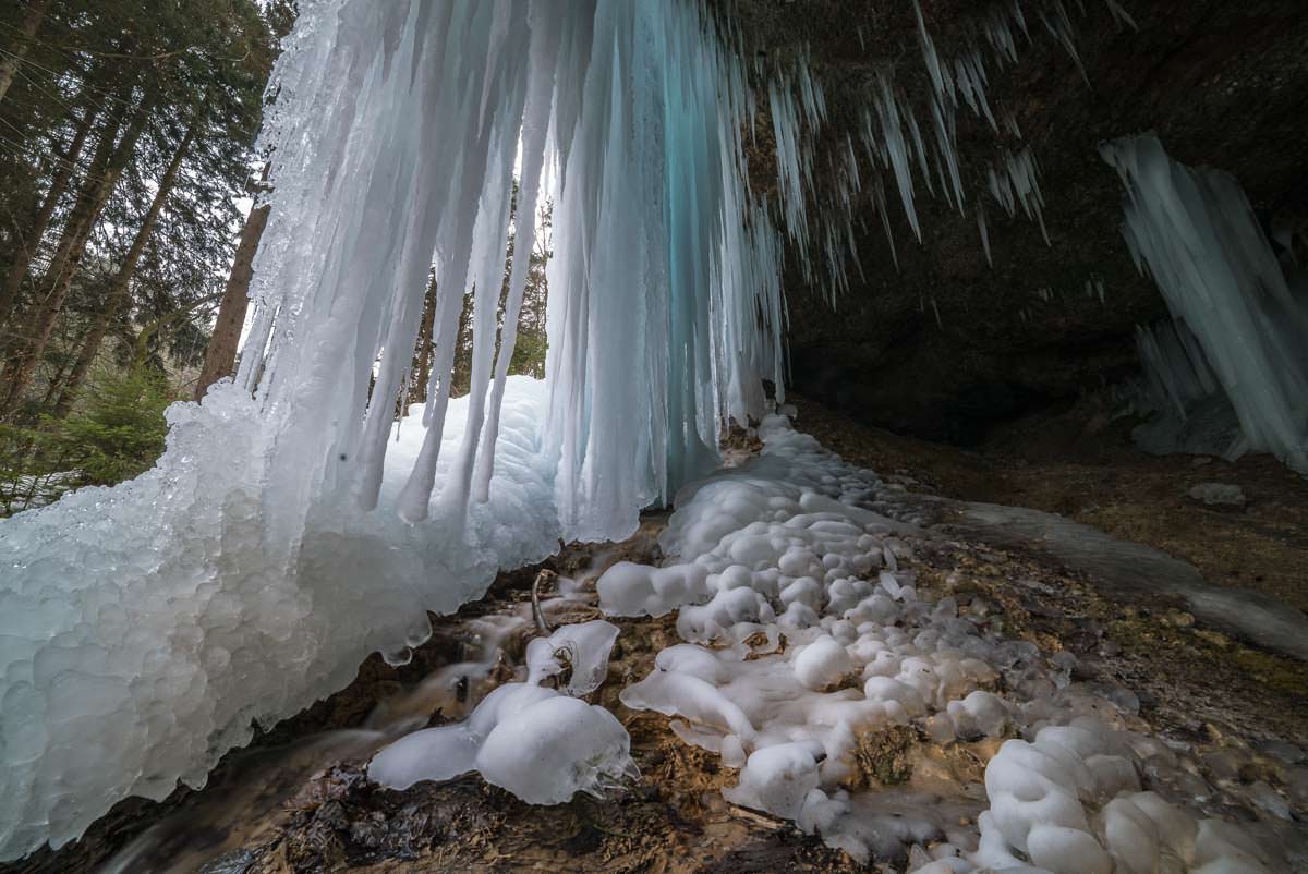 Achtung! Bei Tauwetter können die Eiszapfen von der Decke fallen! Eisgrotte im Eistobel (Allgäu)
