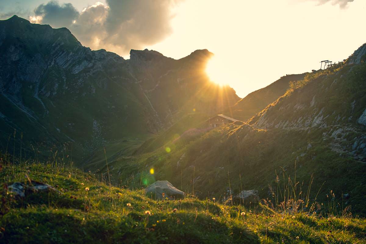 Eine romantische Atmosphäre entfaltet sich, wenn die Sonne über den Almen im Allgäu untergeht