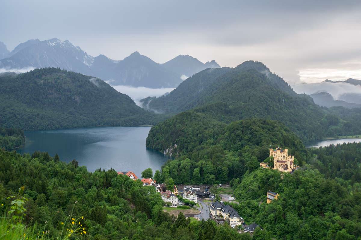 HInter dem Schloss Hohenschwangau liegen Alpsee, Schwansee und die Tannheimer Alpen